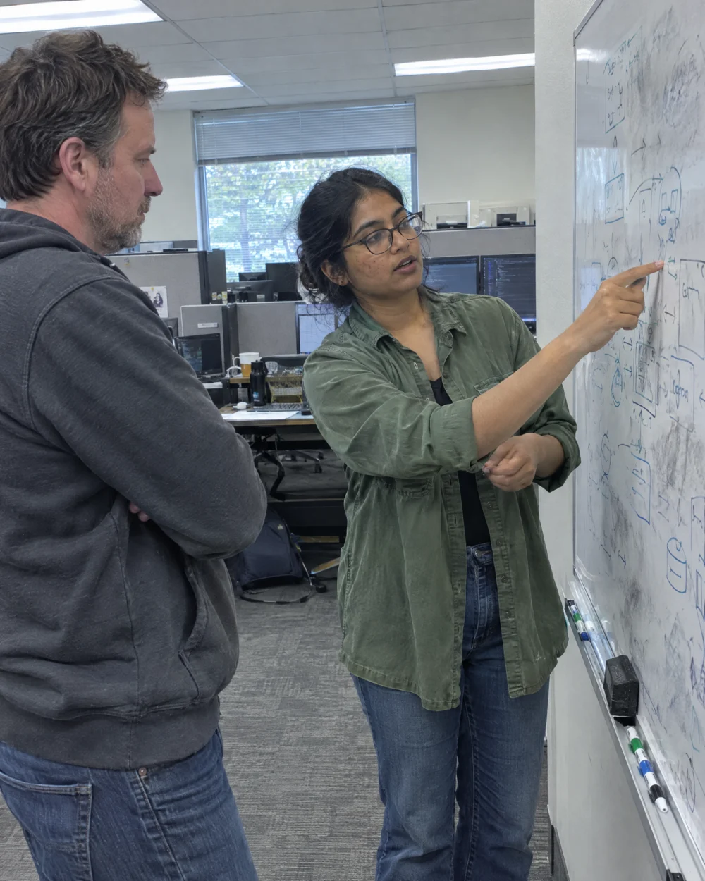 Contract-to-hire developer explaining a system diagram to her team lead