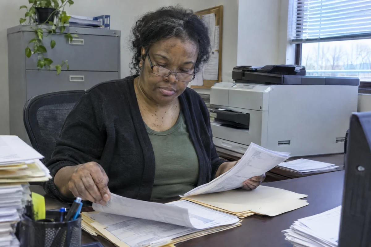 Accounts payable specialist sorting invoices into folders at her desk