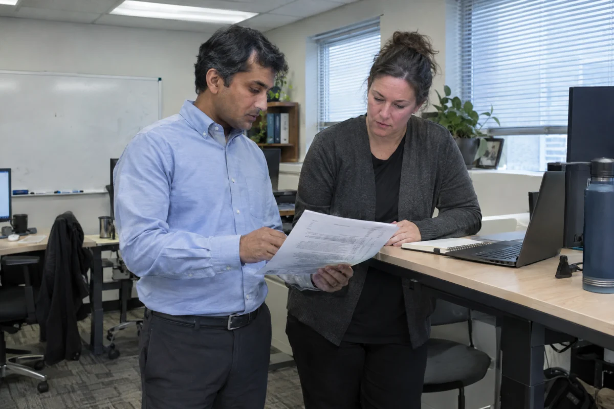 Compliance analyst walking a manager through a printed policy checklist